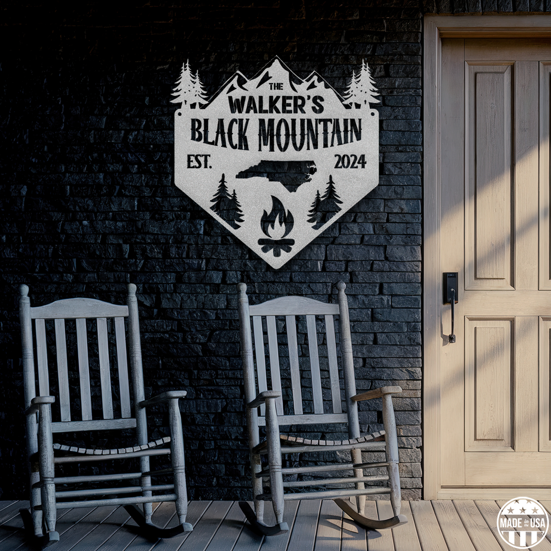 A customizable metal sign is mounted on a brick wall. Beneath the sign are two comfy rocking chairs ready for you!