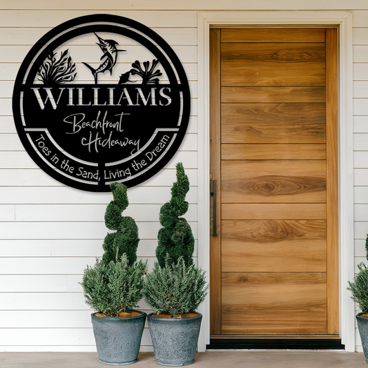 Blank metal sign on the exterior of a house. Plants are beneath it and a wooden door to the side.